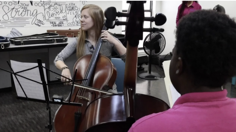 Bethany Uhler Thompson playing cello to girls at Les Peters Academy and Hillsborough Girls Academy